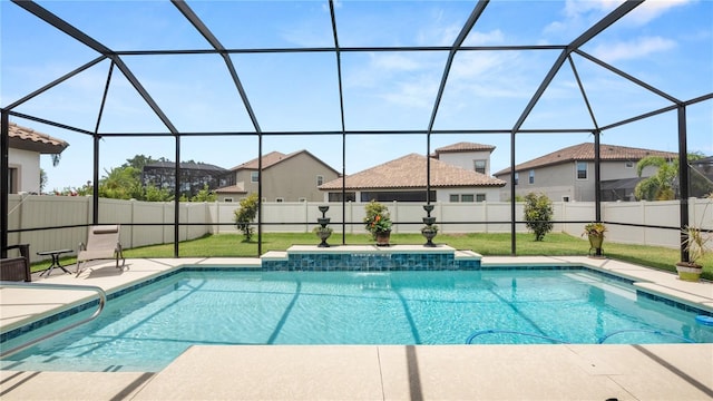 view of pool with a lawn, glass enclosure, and pool water feature