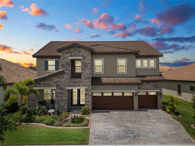 mediterranean / spanish-style house featuring a lawn and a garage