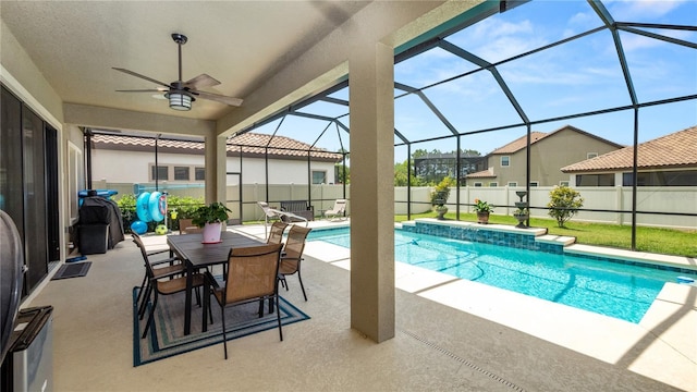 view of swimming pool featuring glass enclosure, ceiling fan, and a patio