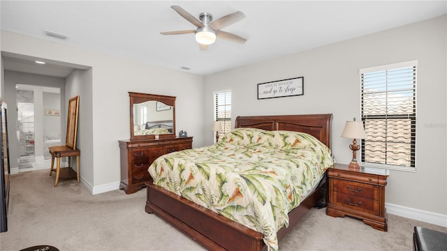 bedroom featuring ceiling fan, light carpet, and ensuite bath