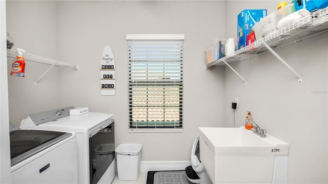 washroom with tile patterned flooring, independent washer and dryer, and sink