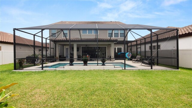 rear view of house featuring a patio, a yard, glass enclosure, and ceiling fan