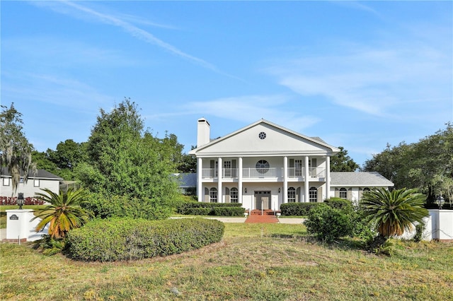 neoclassical / greek revival house with a balcony and a front lawn