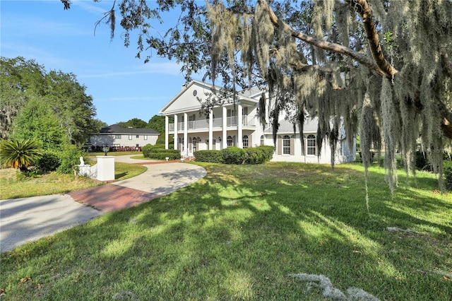 view of front facade with a balcony and a front yard