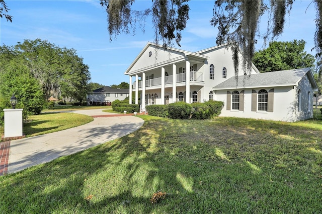 neoclassical / greek revival house with a front yard and a balcony