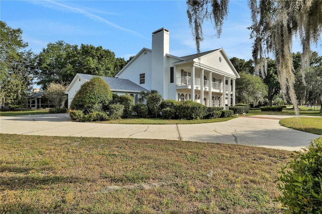 view of property exterior featuring a yard and a balcony