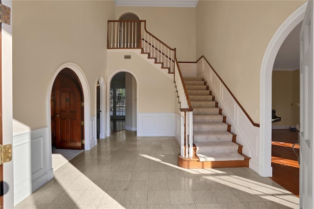 entryway featuring a high ceiling and ornamental molding