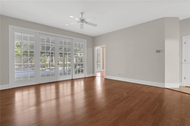 empty room with french doors, ceiling fan, and hardwood / wood-style floors