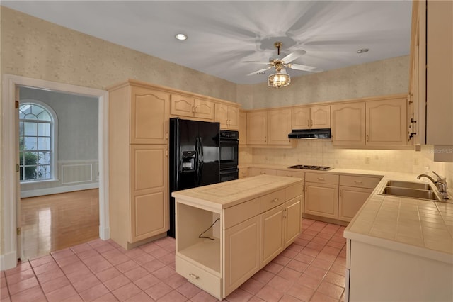 kitchen featuring sink, a center island, tile countertops, light tile patterned flooring, and black appliances