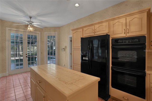 kitchen with tile counters, a center island, french doors, light tile patterned floors, and black appliances