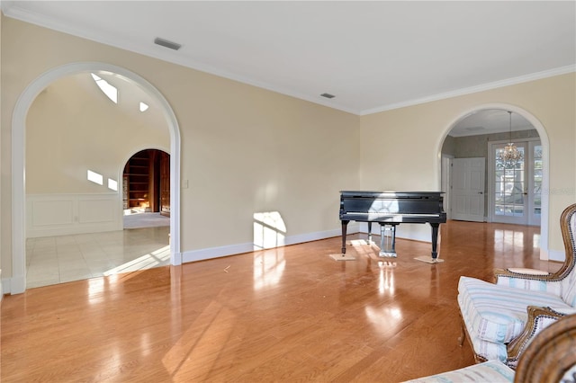 living room with ornamental molding, light hardwood / wood-style flooring, and an inviting chandelier