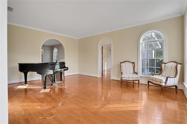 living area with hardwood / wood-style flooring and crown molding