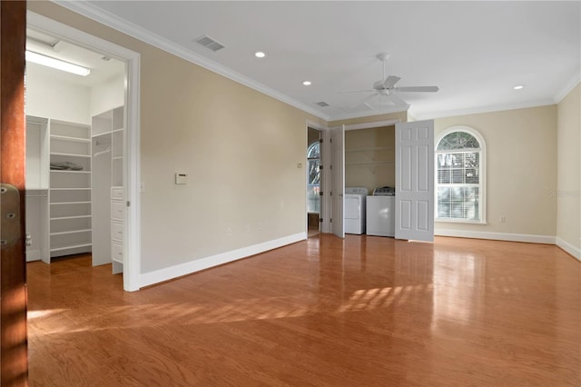 unfurnished room featuring ceiling fan, hardwood / wood-style floors, crown molding, and washing machine and clothes dryer