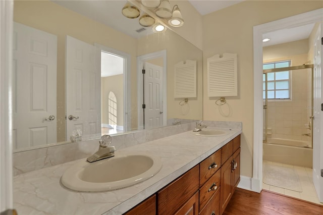 bathroom featuring tiled shower / bath combo, hardwood / wood-style flooring, and vanity