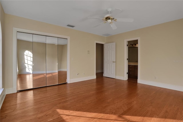 unfurnished bedroom with hardwood / wood-style floors, a closet, and ceiling fan