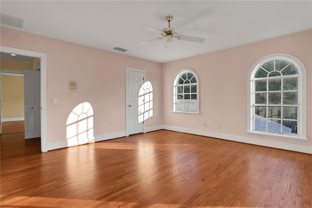 unfurnished room with hardwood / wood-style flooring, ceiling fan, and plenty of natural light