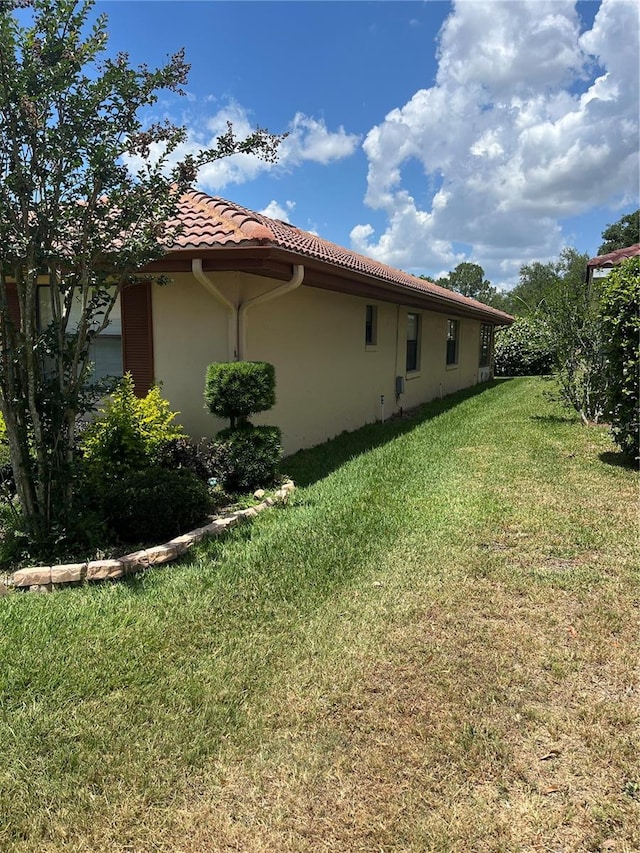 view of side of home with a lawn