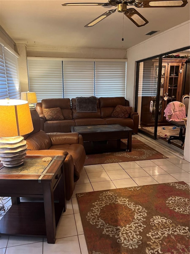 living room with ceiling fan, crown molding, and light tile patterned flooring