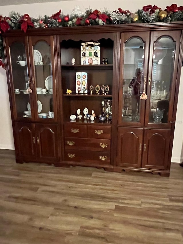 bar with dark brown cabinets and dark hardwood / wood-style floors