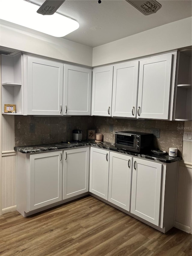 kitchen with hardwood / wood-style floors, white cabinetry, and tasteful backsplash