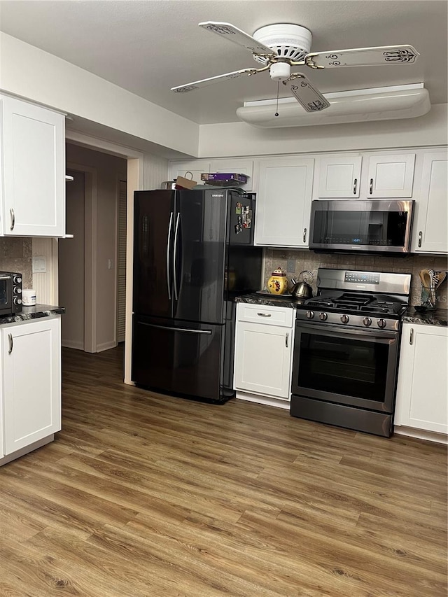 kitchen with ceiling fan, tasteful backsplash, white cabinetry, wood-type flooring, and stainless steel appliances