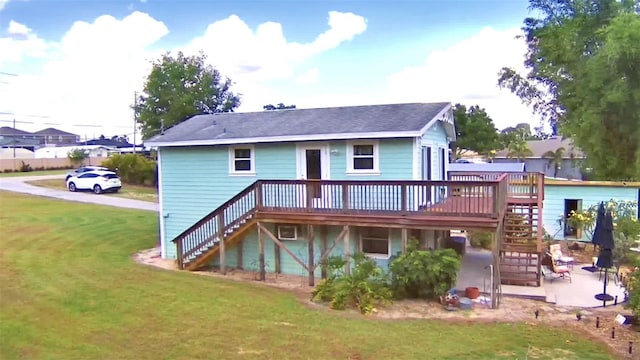 back of house with a patio area, a wooden deck, and a lawn