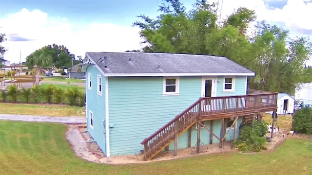 rear view of house with a yard and a deck