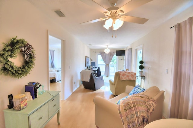 living room featuring light hardwood / wood-style flooring and ceiling fan