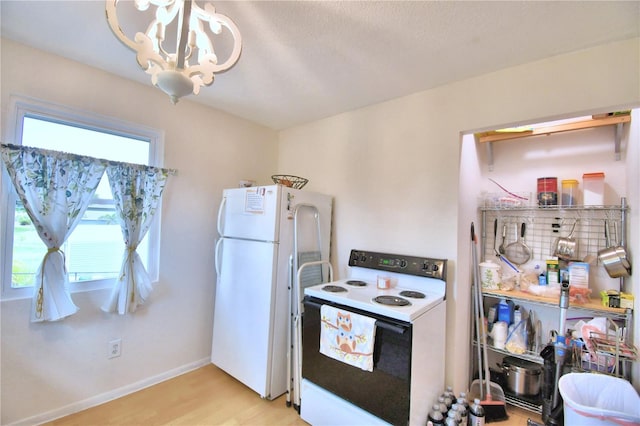 kitchen featuring white appliances, an inviting chandelier, and light wood-type flooring