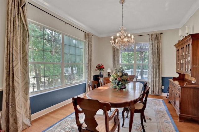 8608 Poinsettia Dr, Temple Terrace, FL 33637 - dining area featuring a healthy amount of sunlight, light hardwood / wood-style floors, a chandelier, and crown molding