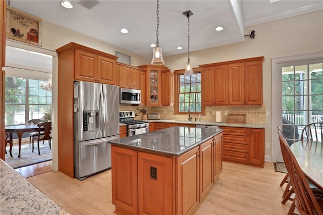 8608 Poinsettia Dr, Temple Terrace, FL 33637 - kitchen with a kitchen island, backsplash, stainless steel appliances, dark stone countertops, and light wood-type flooring