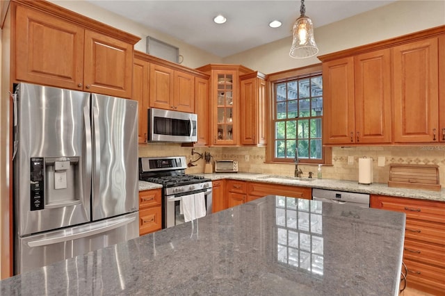 8608 Poinsettia Dr, Temple Terrace, FL 33637 - kitchen with sink, backsplash, hanging light fixtures, stainless steel appliances, and stone counters