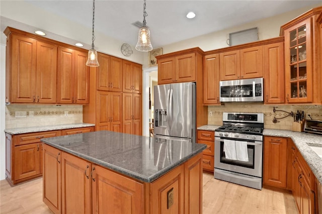 8608 Poinsettia Dr, Temple Terrace, FL 33637 - kitchen featuring a kitchen island, tasteful backsplash, light hardwood / wood-style flooring, and stainless steel appliances