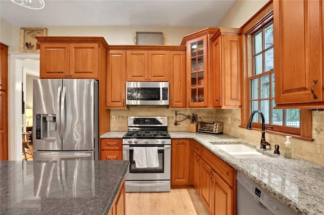 8608 Poinsettia Dr, Temple Terrace, FL 33637 - kitchen with tasteful backsplash, appliances with stainless steel finishes, light hardwood / wood-style floors, and light stone countertops
