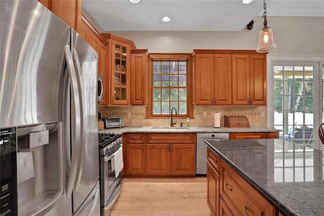 8608 Poinsettia Dr, Temple Terrace, FL 33637 - kitchen with light hardwood / wood-style floors, backsplash, hanging light fixtures, stainless steel appliances, and dark stone countertops