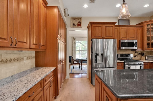 8608 Poinsettia Dr, Temple Terrace, FL 33637 - kitchen featuring tasteful backsplash, pendant lighting, stainless steel appliances, and light wood-type flooring