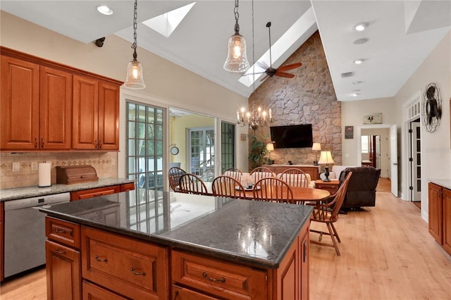8608 Poinsettia Dr, Temple Terrace, FL 33637 - kitchen featuring a kitchen island, light hardwood / wood-style floors, dishwasher, ceiling fan with notable chandelier, and a skylight