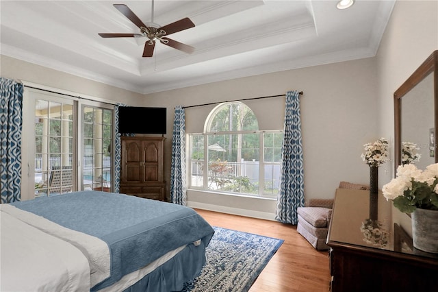 8608 Poinsettia Dr, Temple Terrace, FL 33637 - bedroom with ceiling fan, a tray ceiling, hardwood / wood-style flooring, and multiple windows