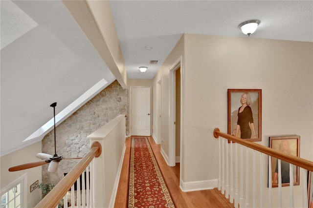 8608 Poinsettia Dr, Temple Terrace, FL 33637 - hallway featuring a textured ceiling, hardwood / wood-style floors, and lofted ceiling with skylight