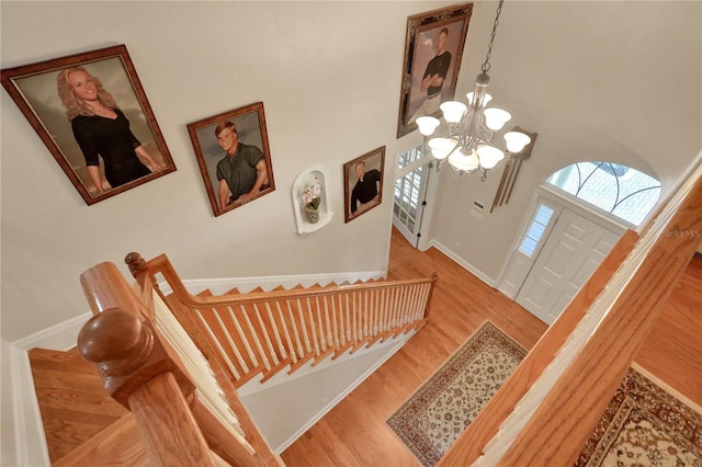 8608 Poinsettia Dr, Temple Terrace, FL 33637 - stairs featuring a notable chandelier, wood-type flooring, and a high ceiling