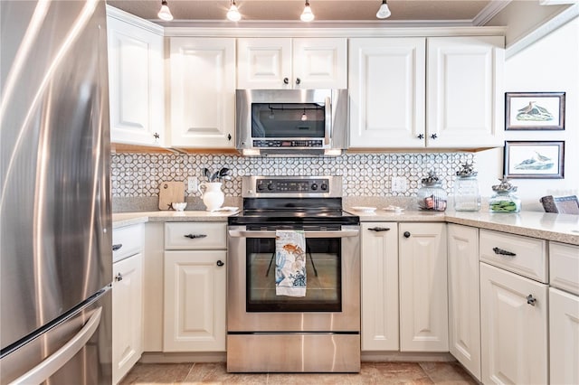 kitchen with white cabinetry, stainless steel appliances, light stone counters, track lighting, and decorative backsplash