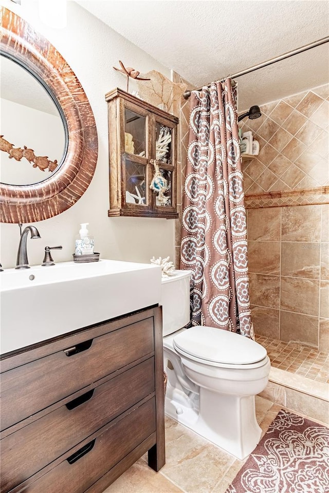 bathroom with vanity, curtained shower, toilet, and a textured ceiling