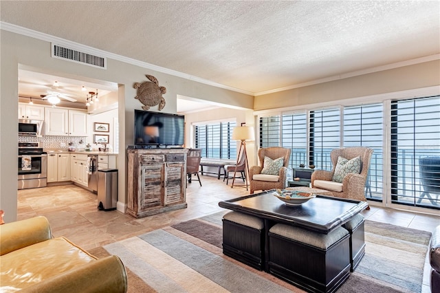 living room featuring ceiling fan, crown molding, and a textured ceiling