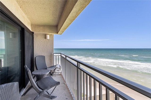 balcony featuring a water view and a view of the beach