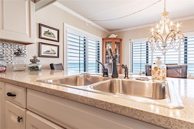 kitchen featuring light stone counters, decorative light fixtures, an inviting chandelier, and sink