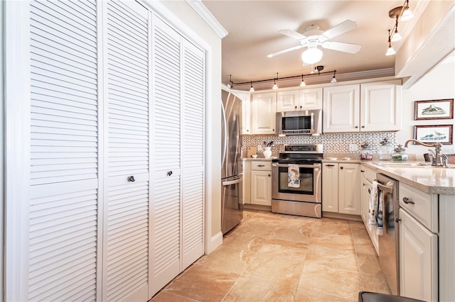 kitchen featuring crown molding, sink, ceiling fan, tasteful backsplash, and stainless steel appliances