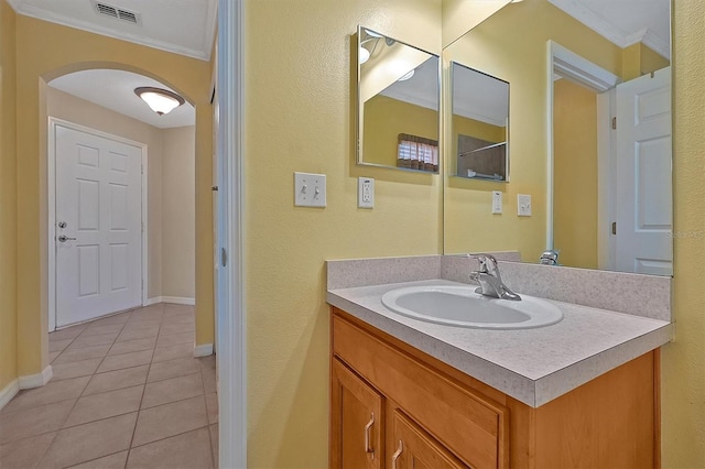 bathroom with tile flooring, ornamental molding, and vanity