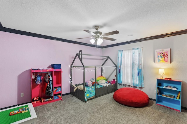 recreation room featuring ornamental molding, carpet flooring, ceiling fan, and a textured ceiling