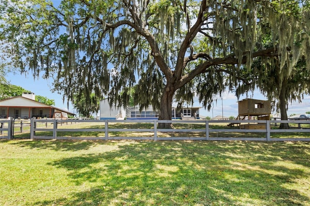 view of home's community with a yard and fence