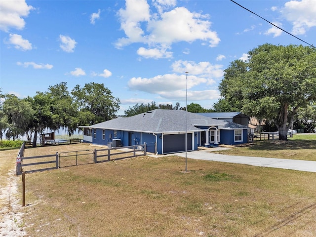 ranch-style home with a garage, driveway, fence, and a front lawn